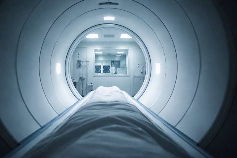 irm-tunnel-examen-medical Vue depuis l’intérieur du tunnel d’un appareil d’IRM, éclairé par une lumière froide et clinique, représentant la perspective du patient pendant l’examen.