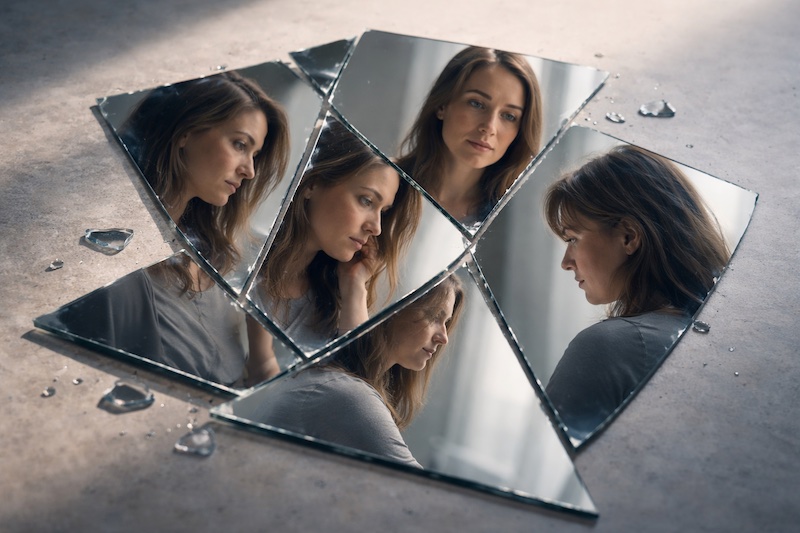 identite-fragmentee-sp Miroir brisé dont les fragments reflètent différentes expressions d’une même personne, symbolisant l’identité fragmentée puis reconstruite après un diagnostic de sclérose en plaques.