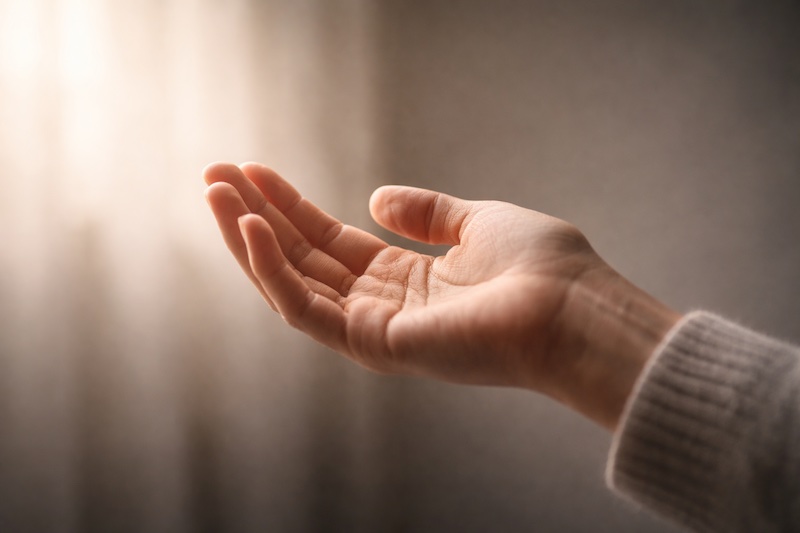 main-tendue-espoir-soutien-sp Main tendue vers le haut, éclairée par une lumière douce, symbolisant l’espoir et le soutien offert après un diagnostic de sclérose en plaques.